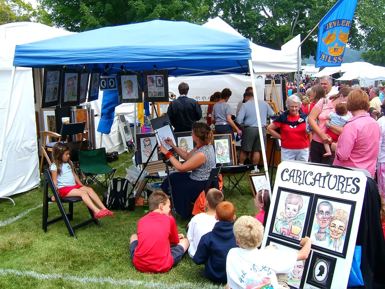 Deb drawing caricatures live at an outdoor art fair